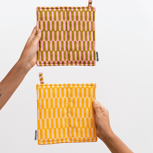 Vattert gryteklut i økologisk bomull med to ulike farger. Praktisk, dekorativ og designet for å henge fremme – ikke gjemmes bort.